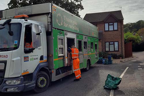 Staff emptying recycling into a recycling vehicle on the roadside